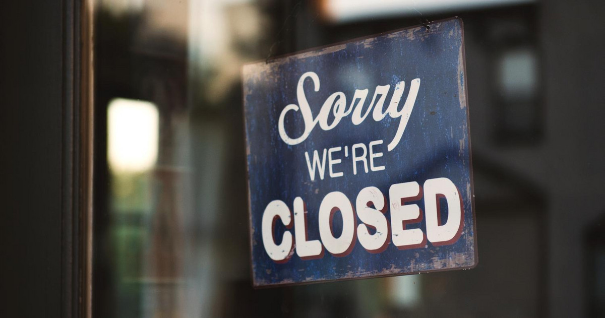 Pic of a closed sign within a shop window
