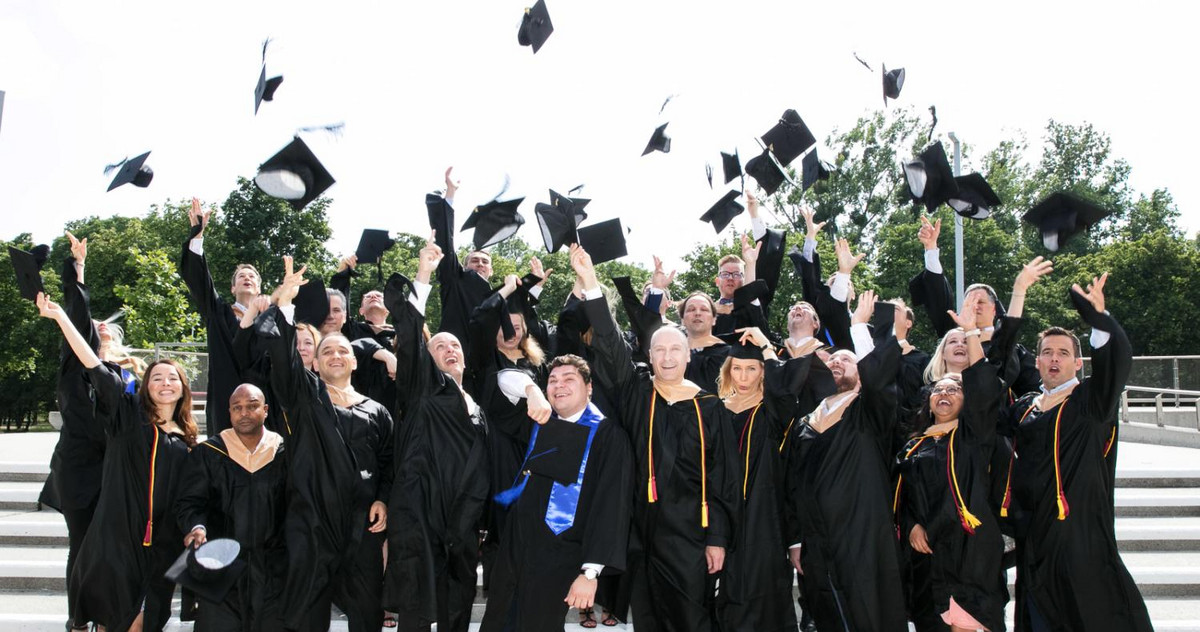 Bild von Studenten die Graduationshut in die Luft werfen