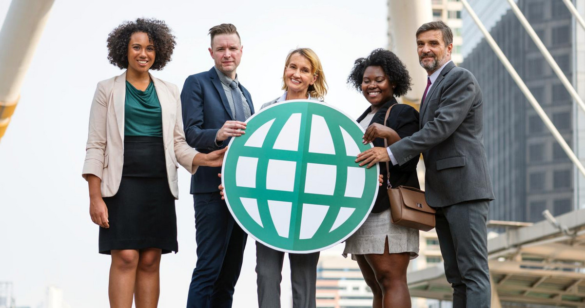 MBA Studenten halten einen ausgedruckten Globus in den Händen
