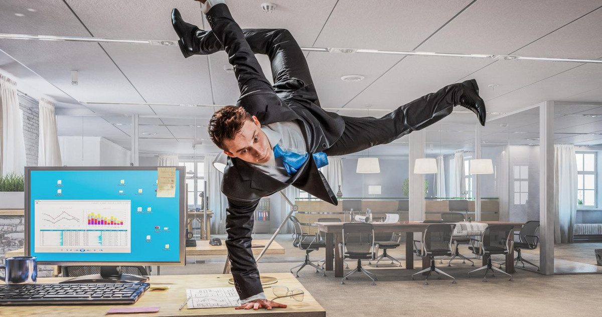 Mann der im Büro Breakdance macht