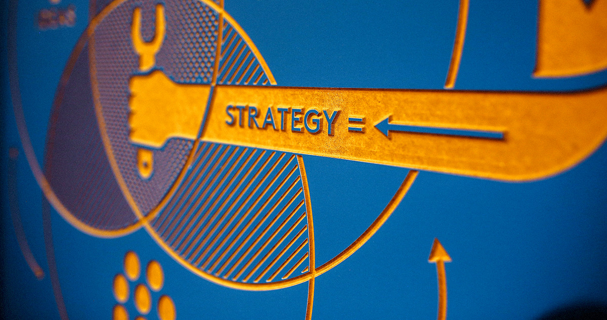 The word "strategy" is written onto a board