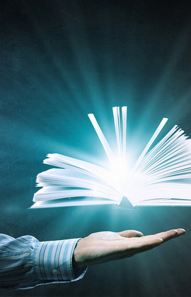 a bright glowing book floating above an open hand