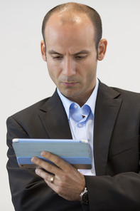 A business man looking concentrated at his tablet computer
