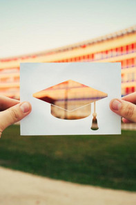 Cut out paper held in front of an MBA school