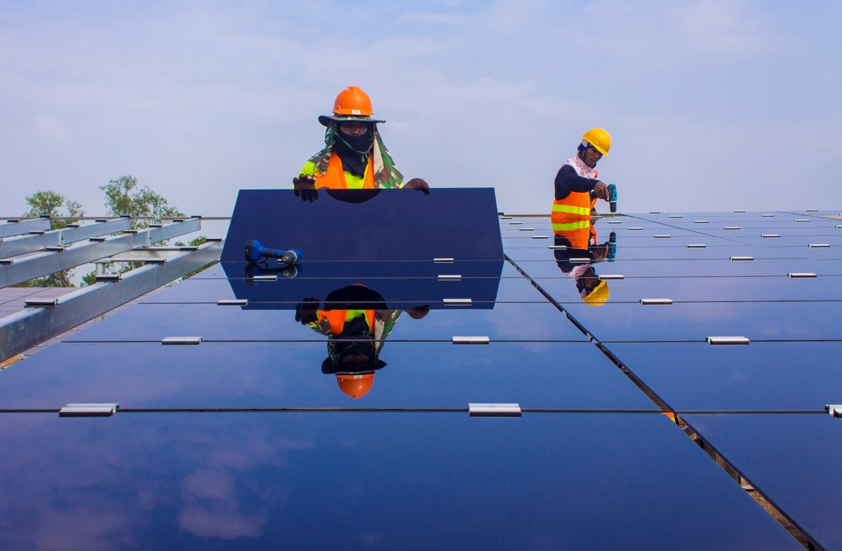 Two workers installing a solar panel