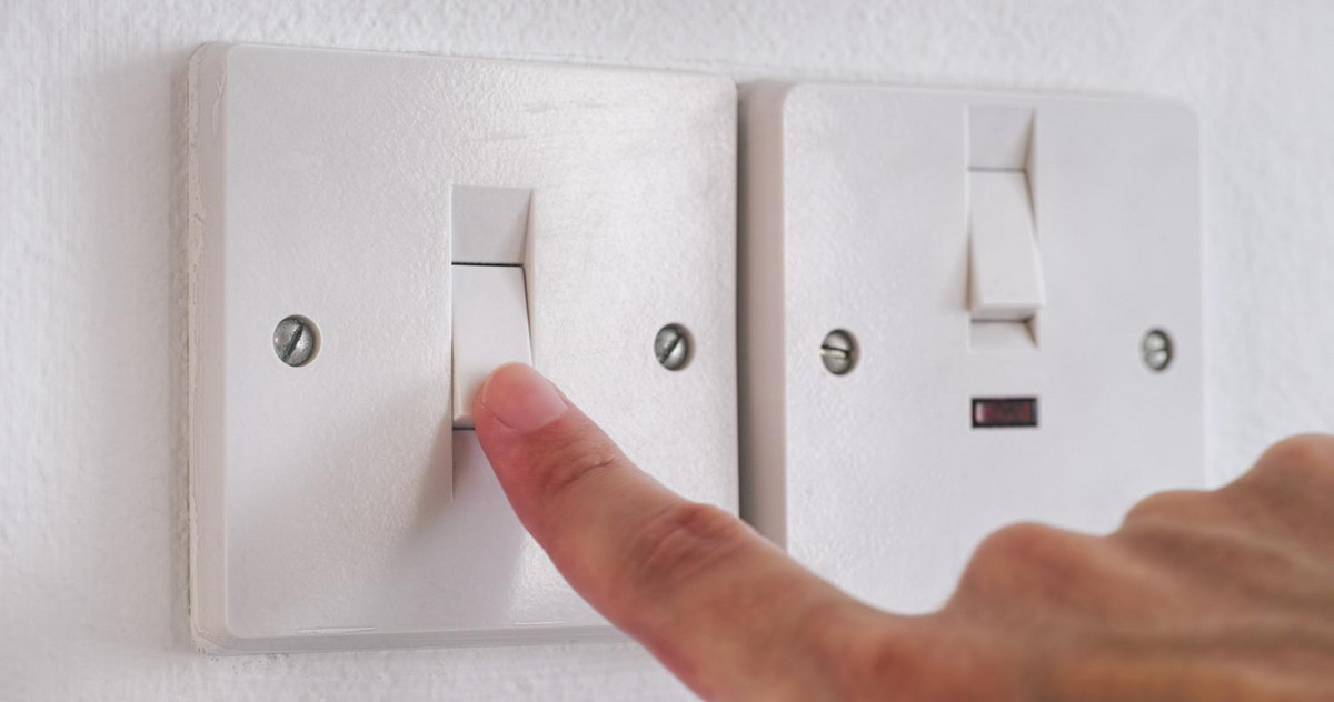 A person turning a light switch on