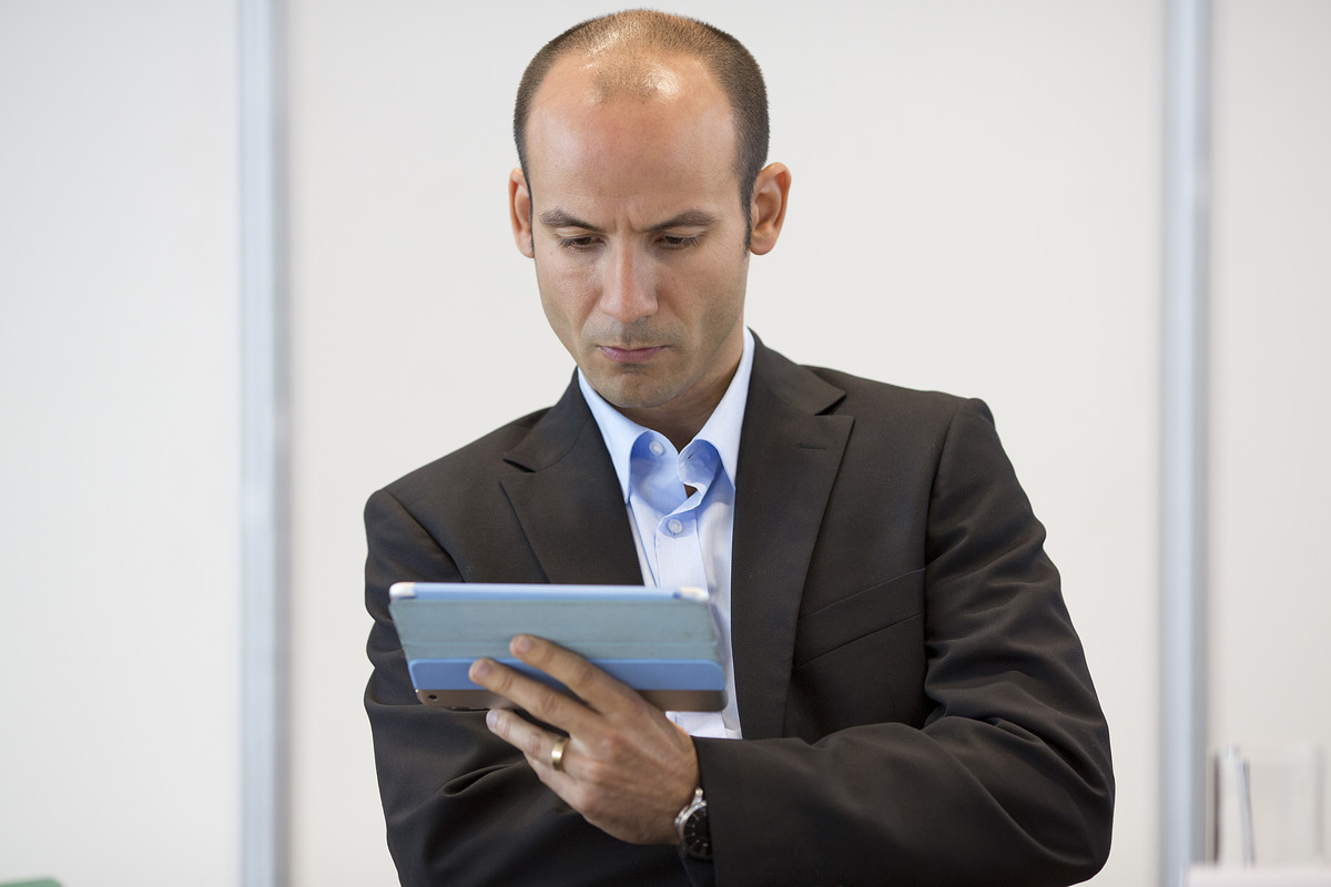 A business man looking concentrated at his tablet computer