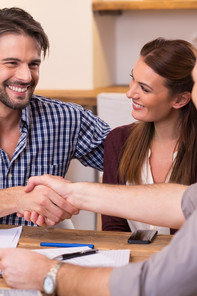 Couple shaking hand to financial agent