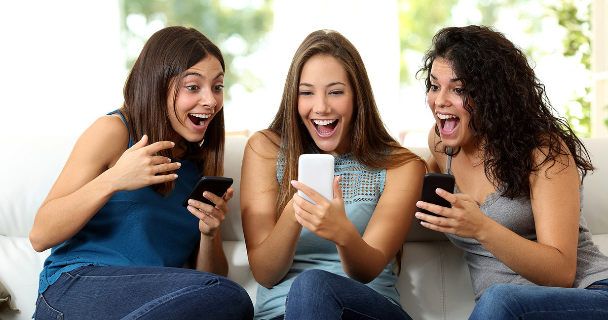 Three women having fun surfing on their smartphones