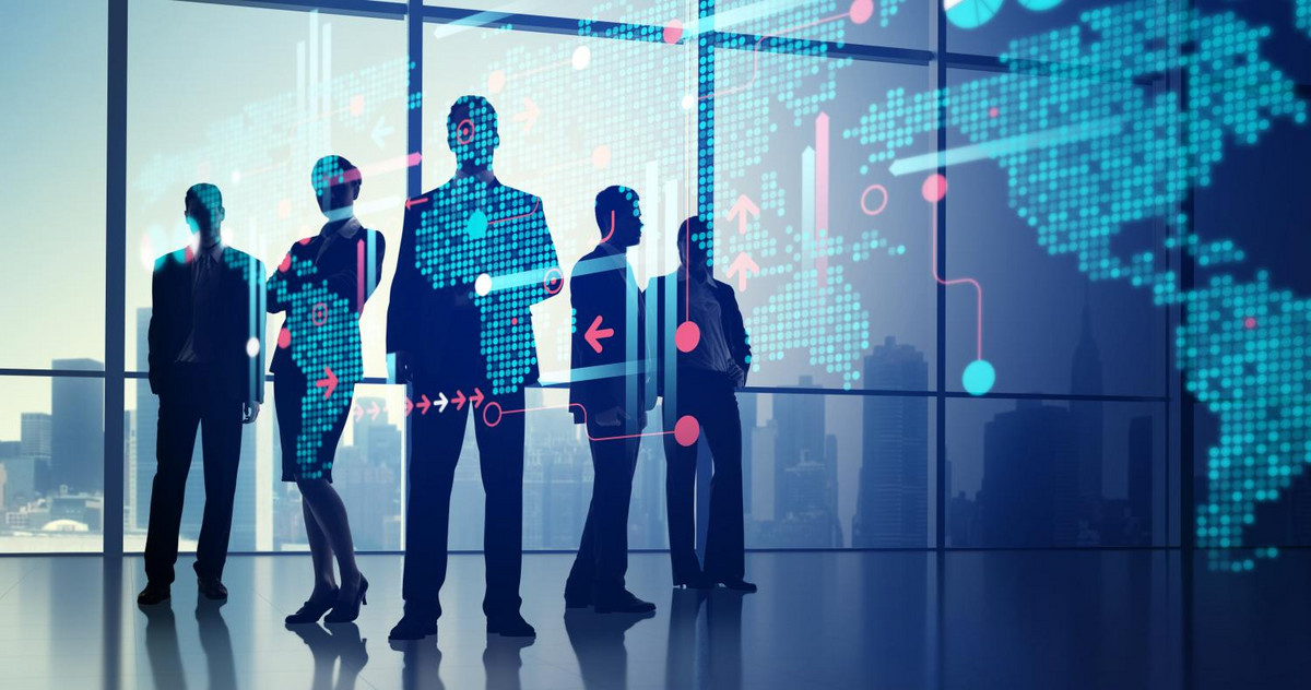 Several business people stand in front of a digital holographic world map