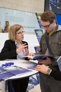 Two people at a fair talking about scholarships