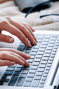 A woman typing something on a laptop