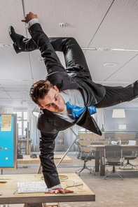 Mann der im Büro Breakdance macht