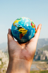A hand holds a globe
