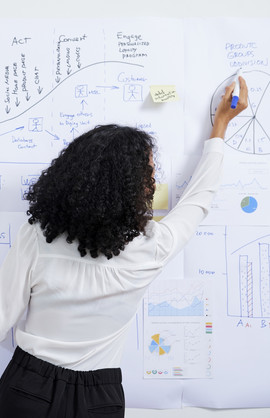 A woman drawing data on a whiteboard