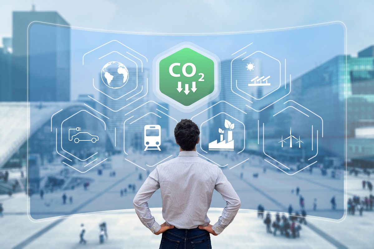 A man standing in front of a holographic display showing various icons - CO2 is highlighted green