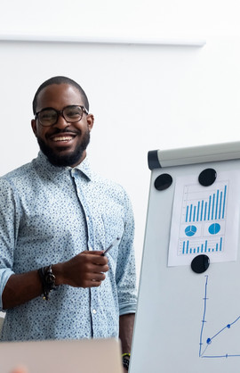 Ein lächelnder Mann zeigt Business-Daten auf einem Whiteboard