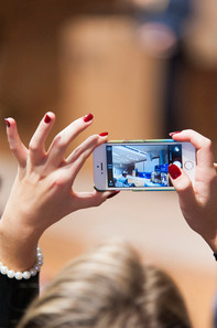 Woman holds iPhone in her hand and films an event