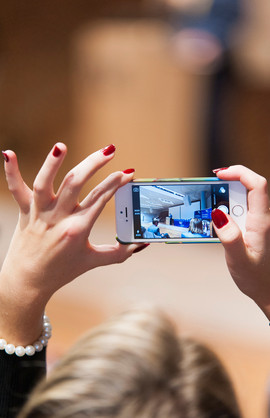 Woman holds iPhone in her hand and films an event