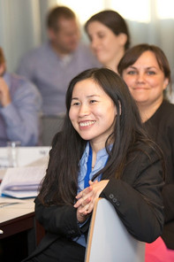 A chinese lady smiling and listening during MBA class