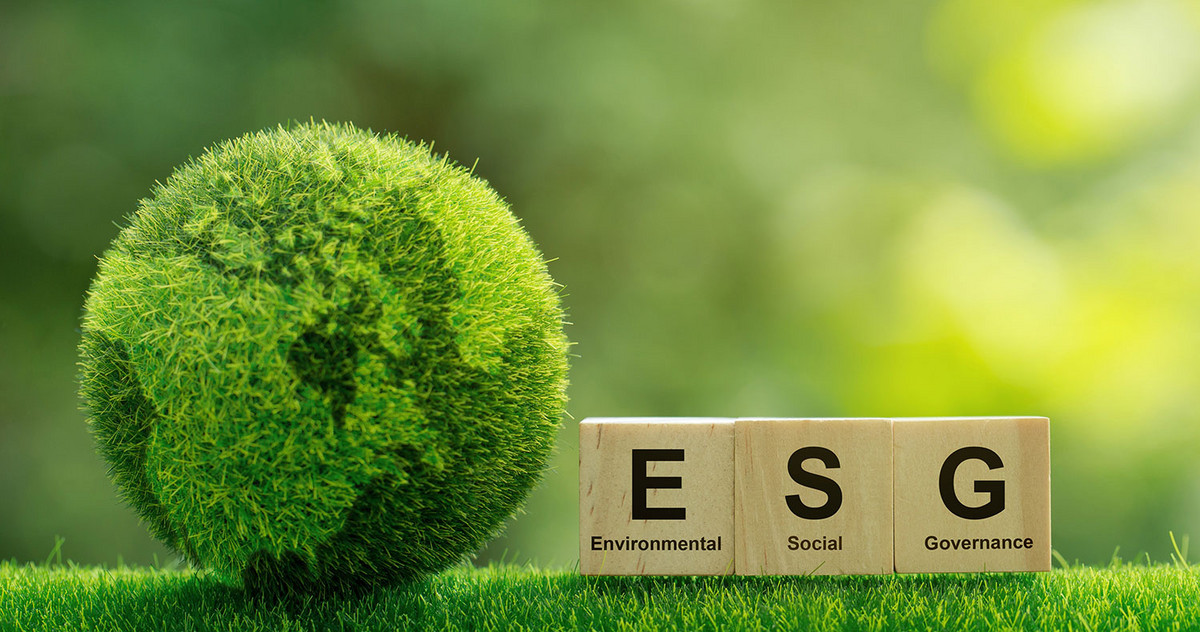 A globe made of grass, next to it wooden bricks with the inscription "ESG - Environmental Social Governance".