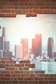 View through a smashed brick wall on a city's skyline