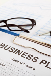 A business plan, glasses and a pencil