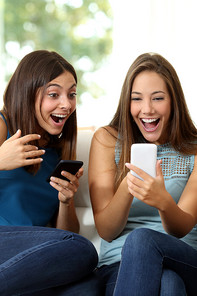 Two women having fun surfing on their smartphones
