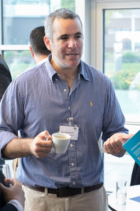 A man with a cup of coffee in his hand talking
