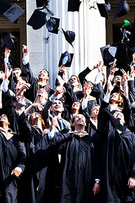 Absolventen werfen ihre Graduierungshüte in die Luft