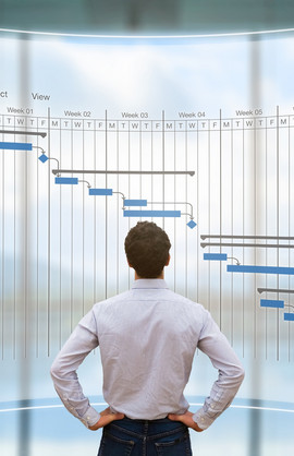 A business man looking at a projection of a Gantt diagram